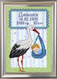 Framed cross-stitch birth sampler with a stork carrying a baby and Cyrillic birth details
