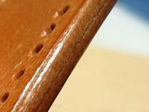 Burnished edge of a leather strap with holes