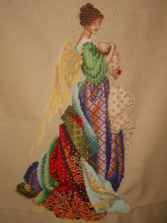 Beaded embroidery of an angel holding a baby, with a multicoloured flowing robe
