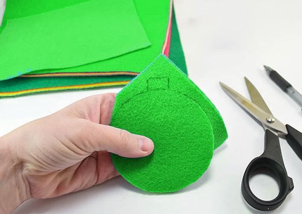 Cutting a circular piece from green felt