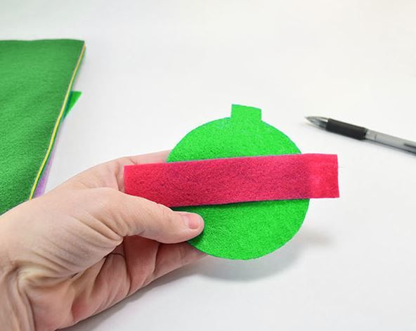 Red felt strip on a green circular toy piece
