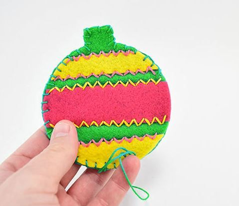 Decorated circular felt toy for a cat