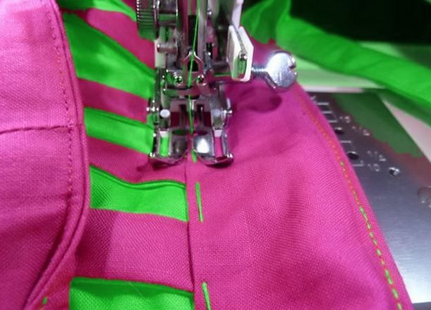 Stitching the side of a bright bag on a sewing machine