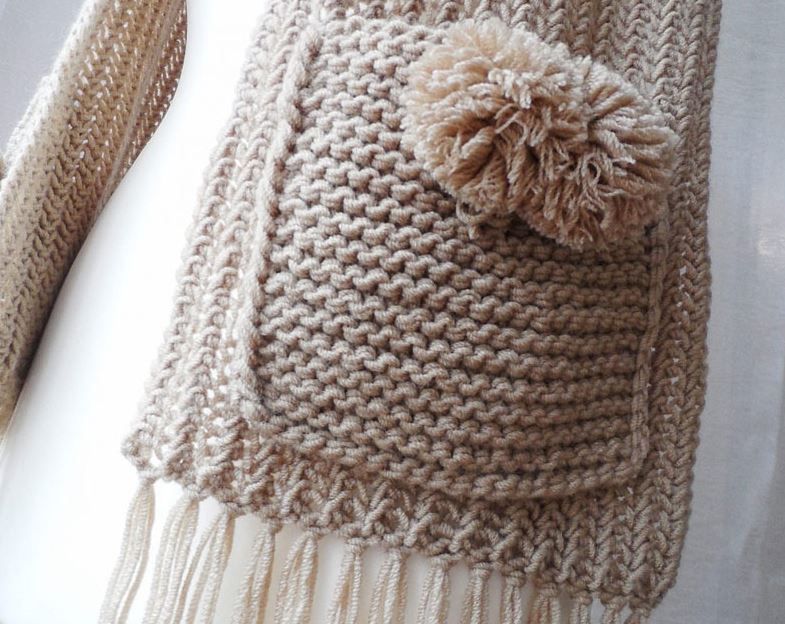 Pocket of a knitted scarf with a pom-pom