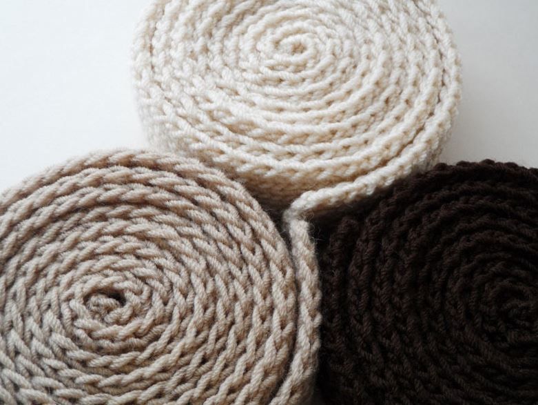 Three knitted strips rolled into rolls