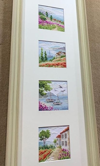 Four miniature landscape embroideries displayed vertically in one frame