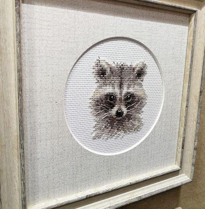 Framed miniature embroidery of a raccoon