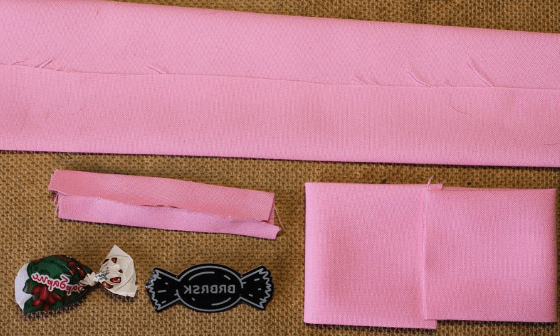 Cut fabric pieces for a pink bow tie and strap