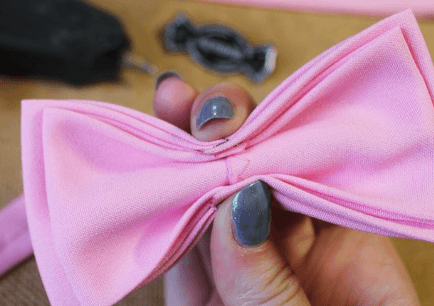 Folded pink bow tie gathered at the center