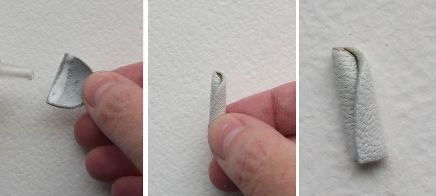 Rolling a narrow piece of white leather for the brooch