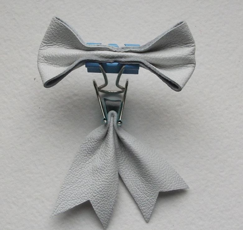 A bow made from white leather with ties, for the brooch