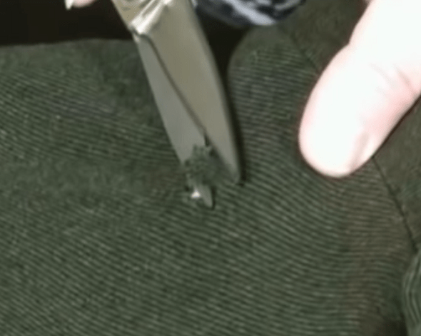Trimming the loose threads around the hole in the pants