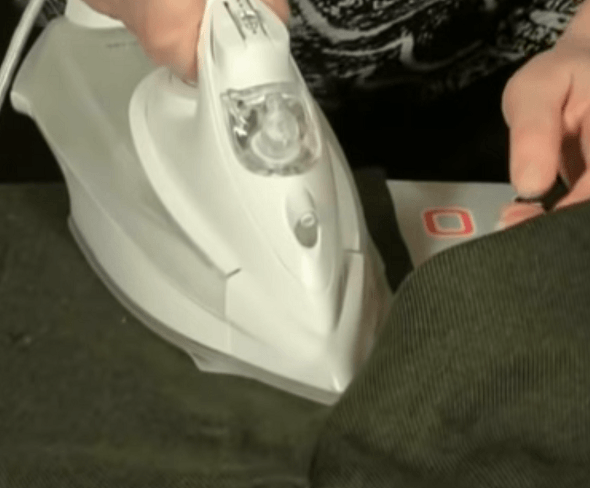 Ironing the patch on the pants through paper