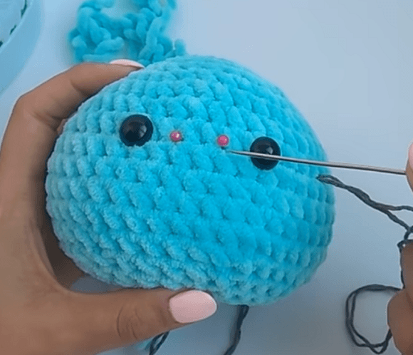 Утяжка лица вязаной игрушки иглой и нитью