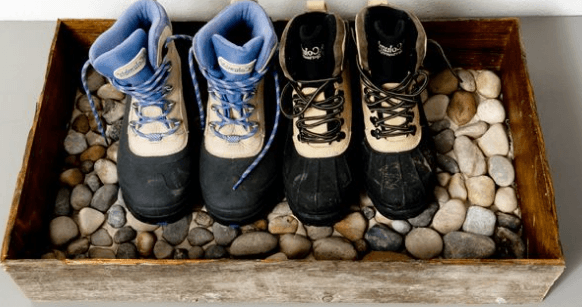 A boot tray filled with river pebbles for the entryway