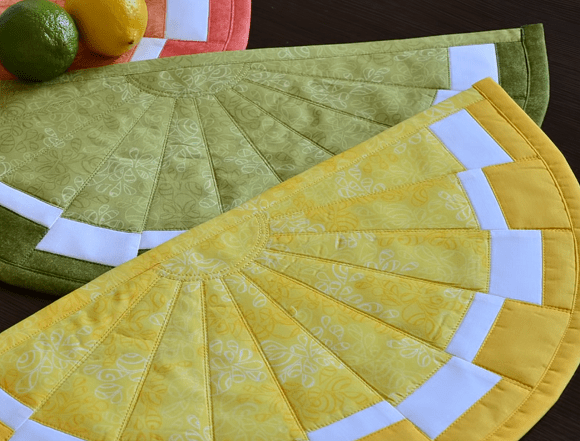 Two finished hot pads shaped like fruit slices