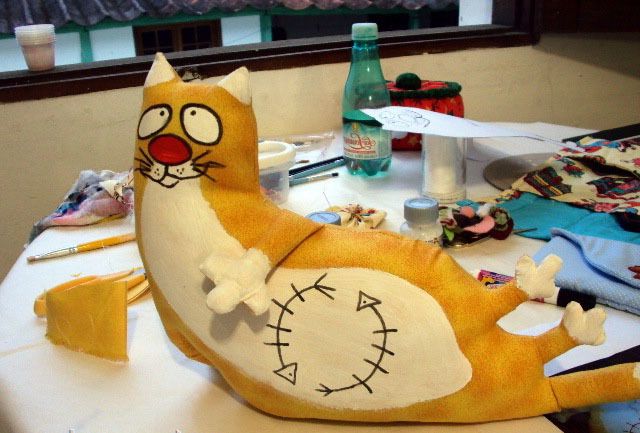 Painted cat face and fish skeleton on the doorstop's belly