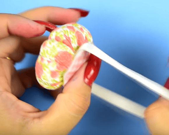 Threading the elastic through the mount on the pincushion
