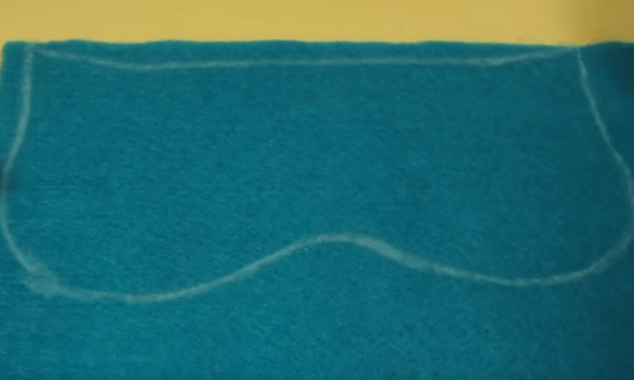 Sleep mask pattern outline traced onto blue fabric