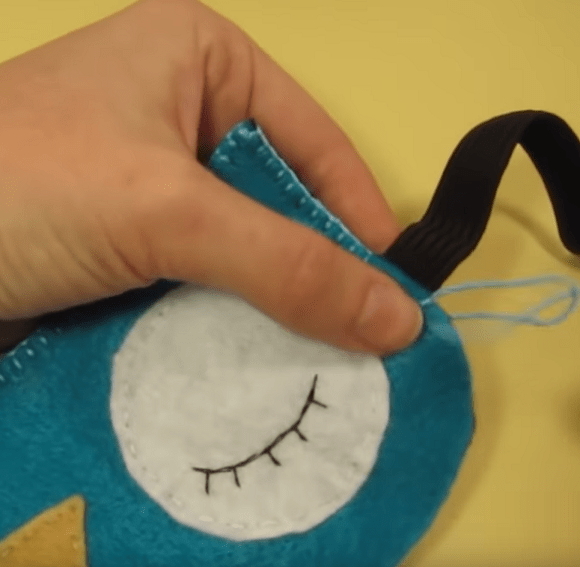 Sewing an eye piece onto an owl-shaped sleep mask