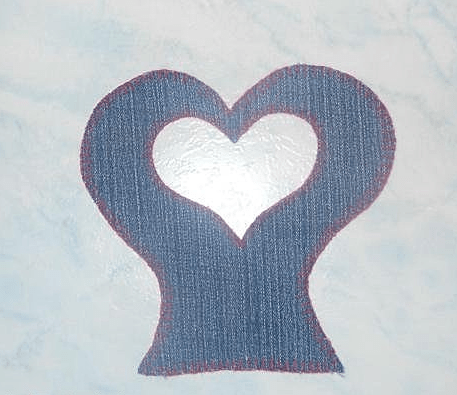 Close view of the heart-shaped denim upper apron piece with hand stitching