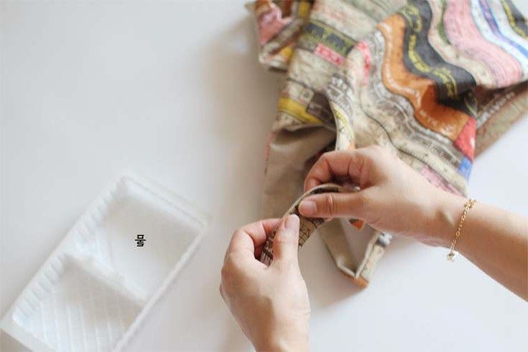 Hand-sewing a snap or closure onto the bag