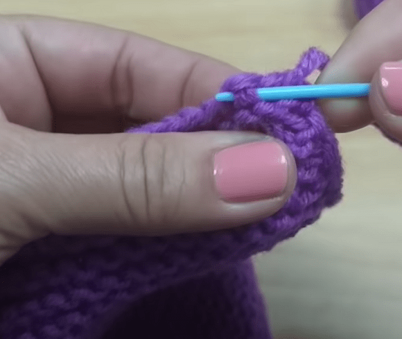 Gathering the toe of a footie slipper with a needle through edge stitches