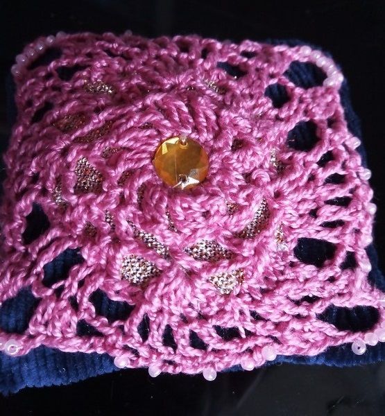 Center of the crocheted pincushion with a button