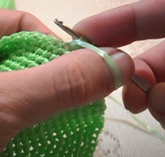 Forming elongated loops with a crochet hook on a green washcloth