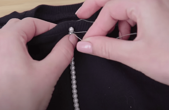 Hand-sewing beads onto the fabric