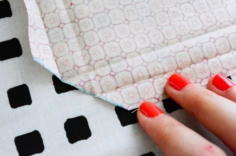 A fabric corner folded along the marked diagonal