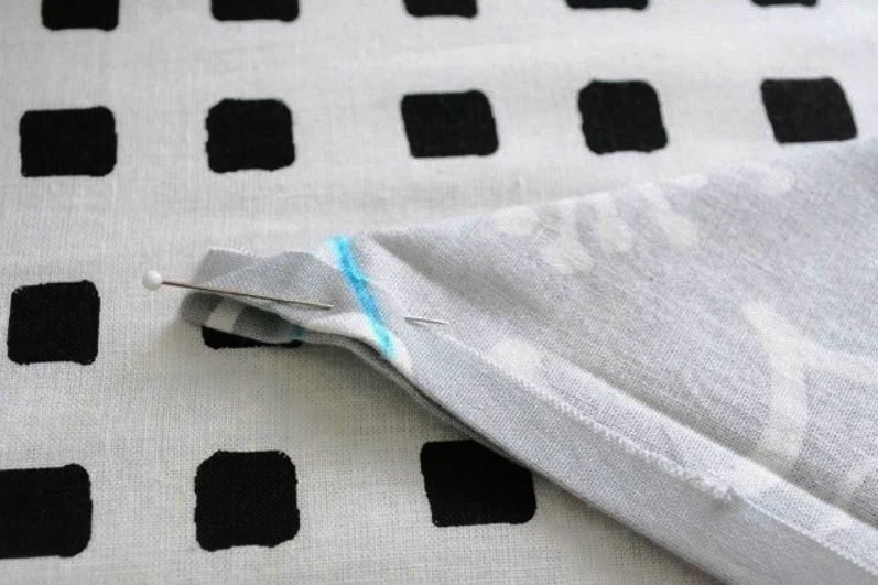 A folded fabric corner pinned in place