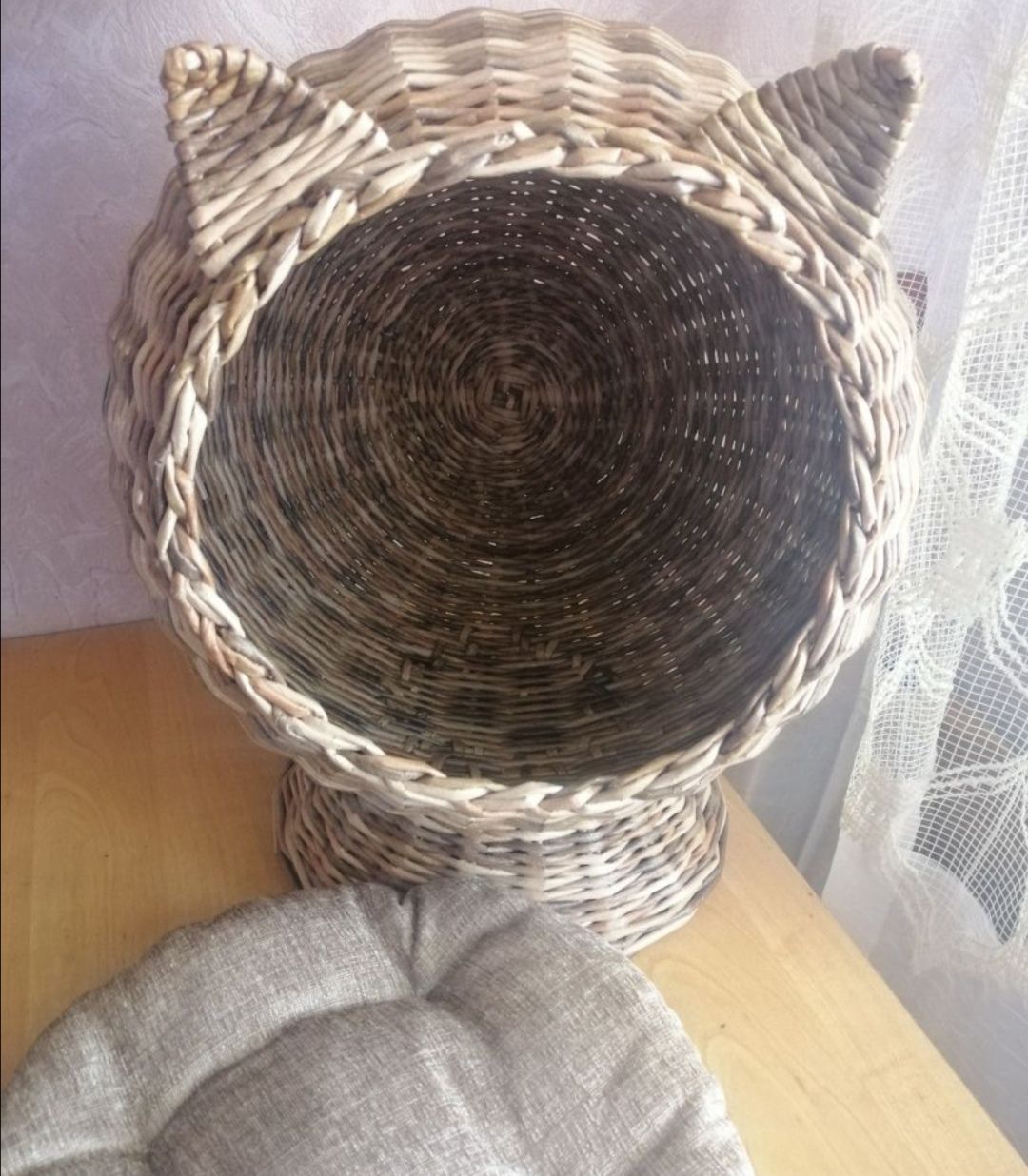 Woven cat house with a round entrance and ears