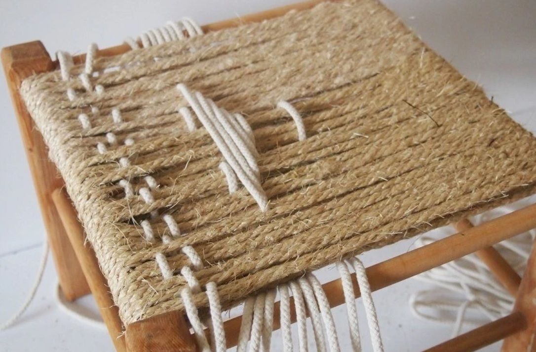 Contrasting white cord woven across a rope stool seat