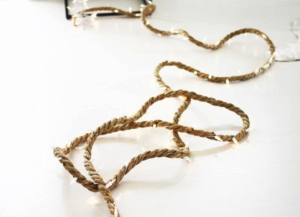 Rope-wrapped string lights laid loosely on a table