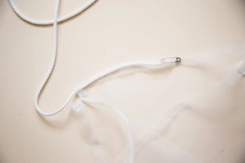 Threading cord through a bag casing with a pin