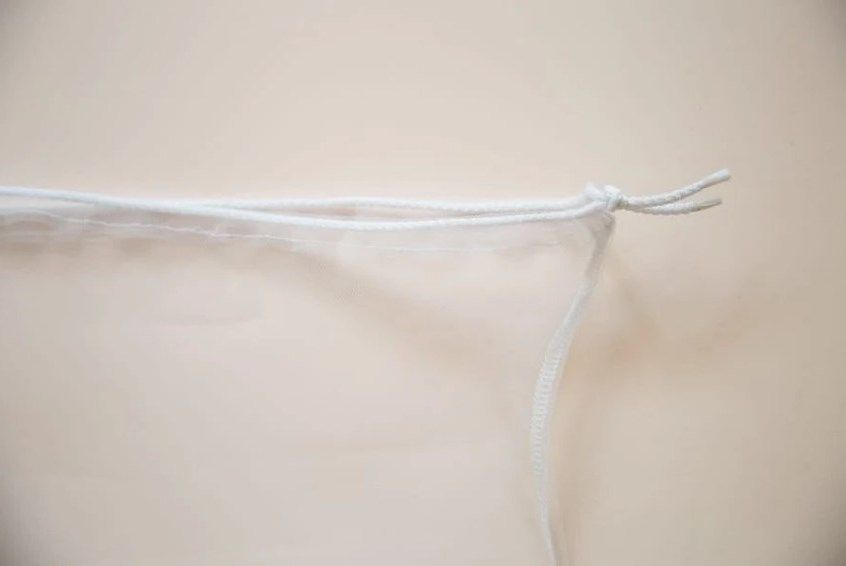 Top edge of a bag with the drawstring pulled tight