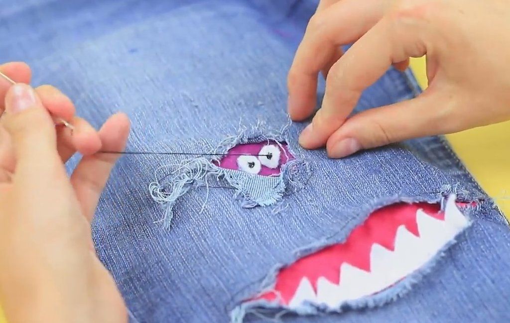 Sewing an eye onto a decorative patch on jeans