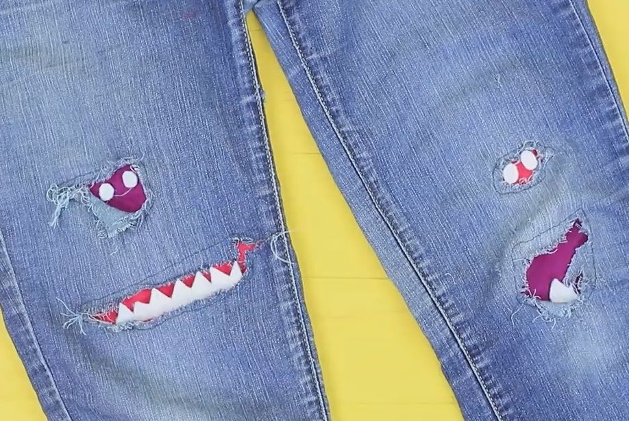 Kids' jeans with patches and teeth in the cuts