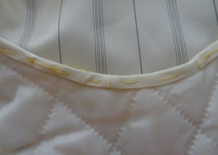 Finished bias tape neatly stitched along the armhole edge