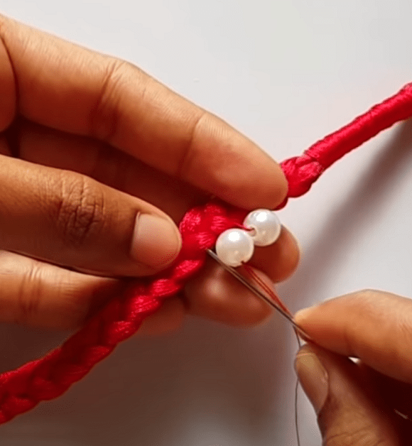 Hand-sewing beads onto the braid