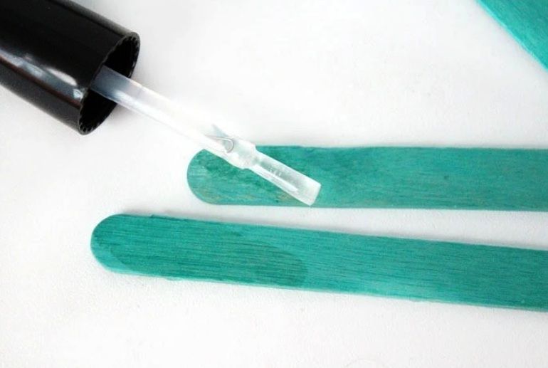 Small wooden craft element coated with clear nail polish