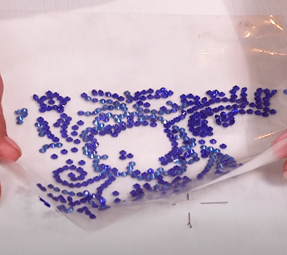 Transfer film with rhinestones positioned on a garment