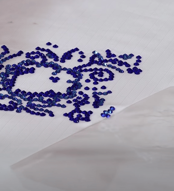 Transfer film being peeled from a cooled rhinestone design