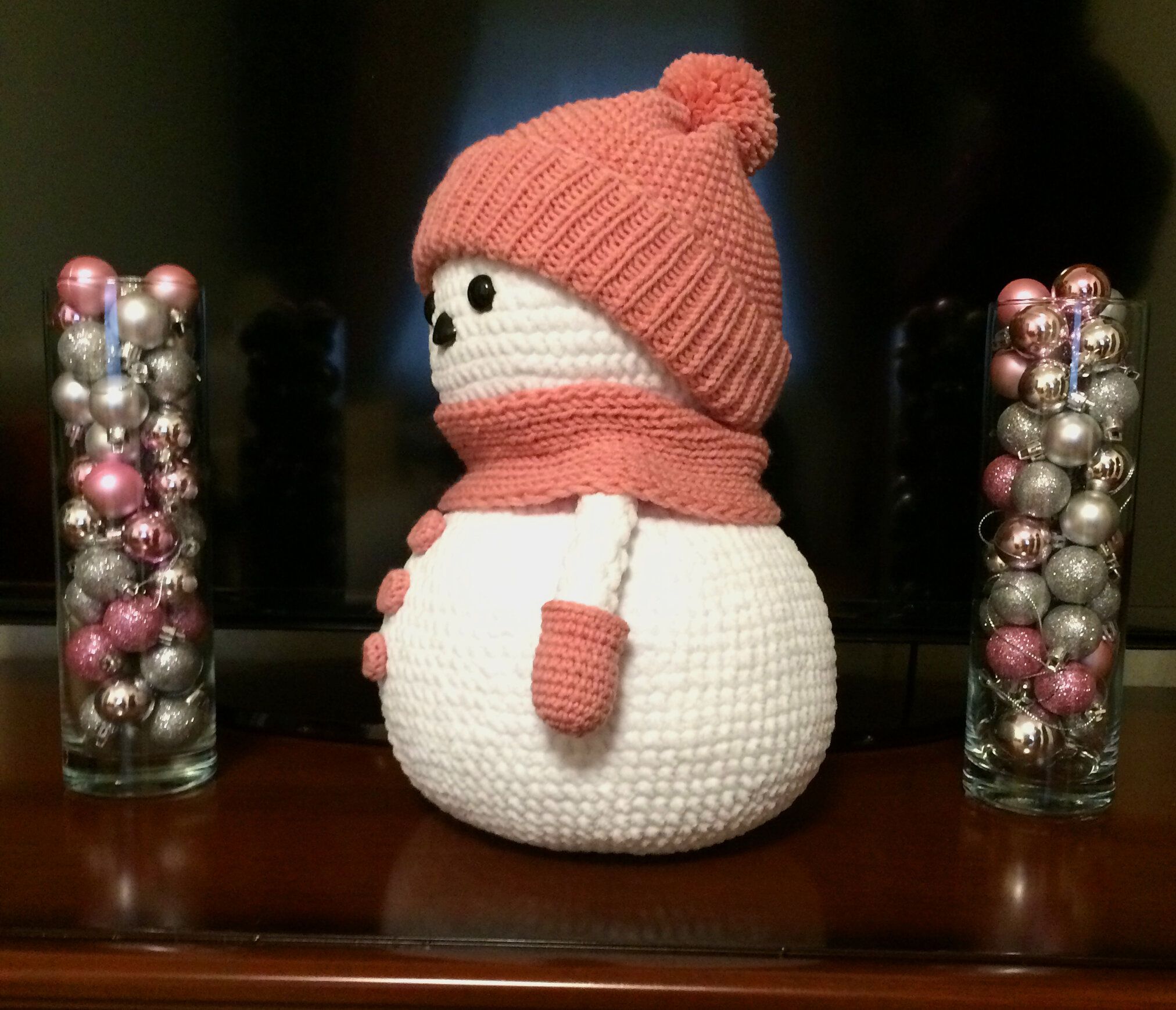 Knitted snowman in a pink hat, side view