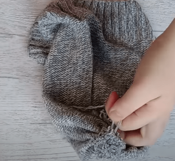 Stitching the sweater hat piece on a sewing machine