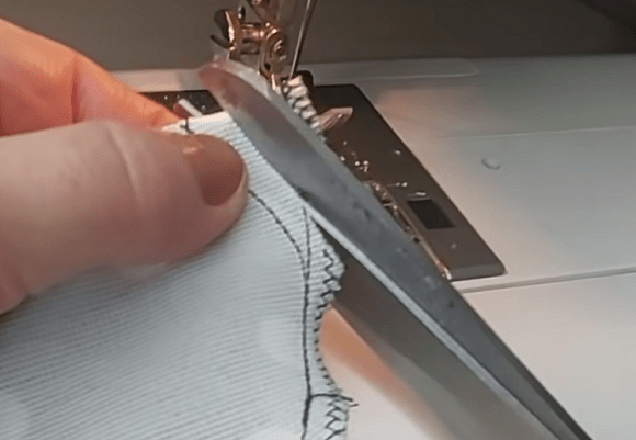Finishing the edge of a knit fabric footie with overlock stitching