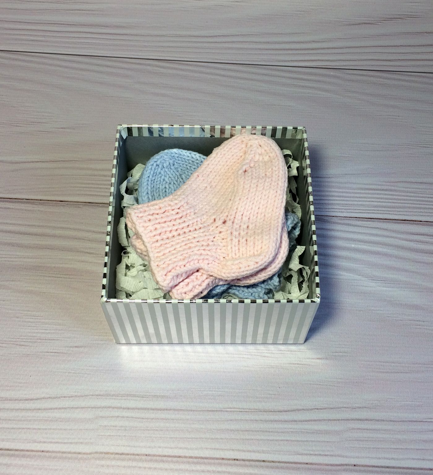 Pair of hand-knitted baby socks in a gift box