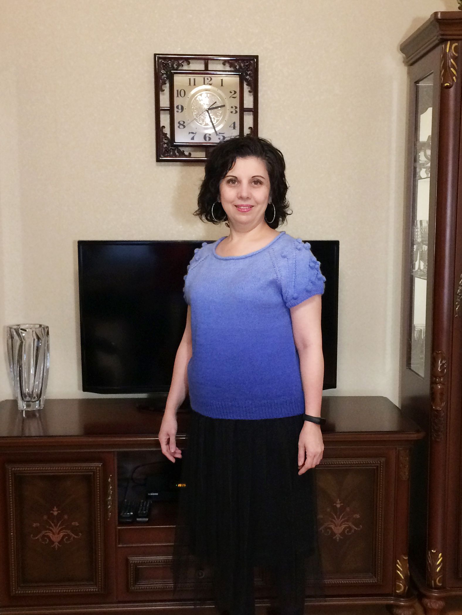 Woman in a blue jumper with short lace sleeves, front view