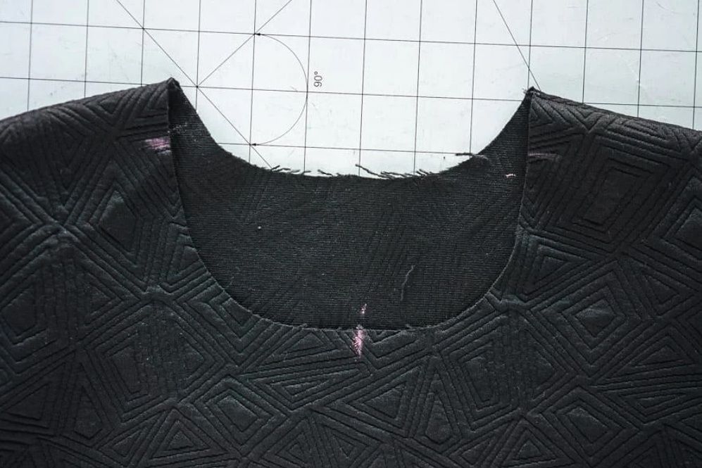 Garment neckline before stitching the trim piece